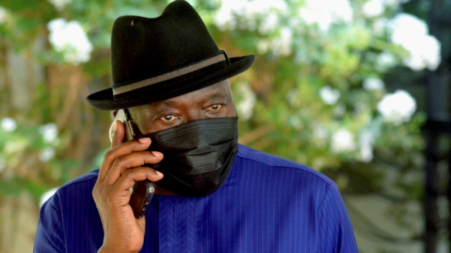 Nigeria's ex-President Goodluck Jonathan wearing a black hat and face mask talking on a phone in Bamako, Mali - Wednesday 26 May 2021