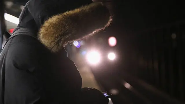 Woman looks at her phone on the New York subway