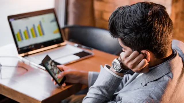Un hombre procrastinando con su celular.