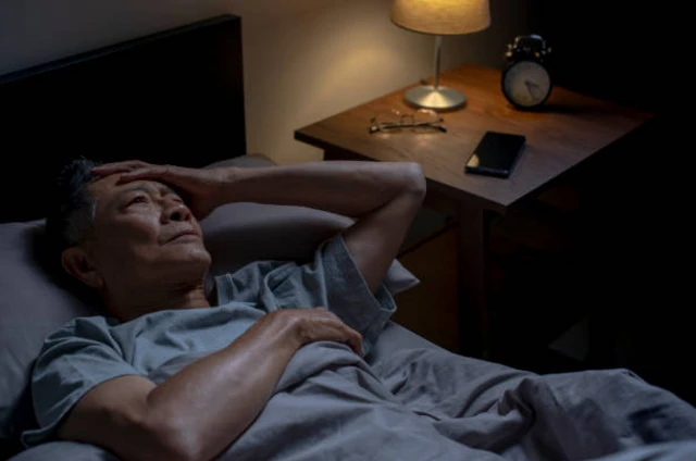 รูปคนแก่นอนมือก่ายหน้าผาก