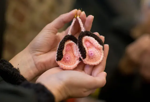 A pair of crochet vulva earrings on sale during the press preview of the new Vagina Museum in Camden market