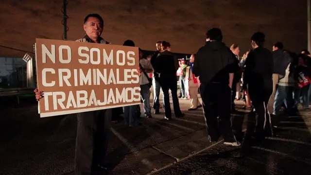 Homem segura cartaz que diz 'Não somos criminosos, trabalhamos'