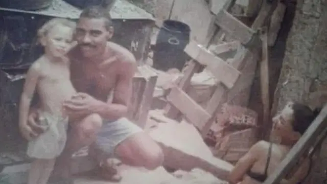 Em foto antiga, Amarildo aparece ao lado de criança