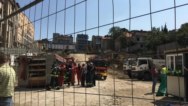 Gradilište, vatrogasna kola, radnici i vatrogasci