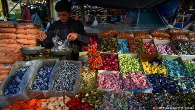 معروضات من الحلوى وتاجر ينصب الميزان