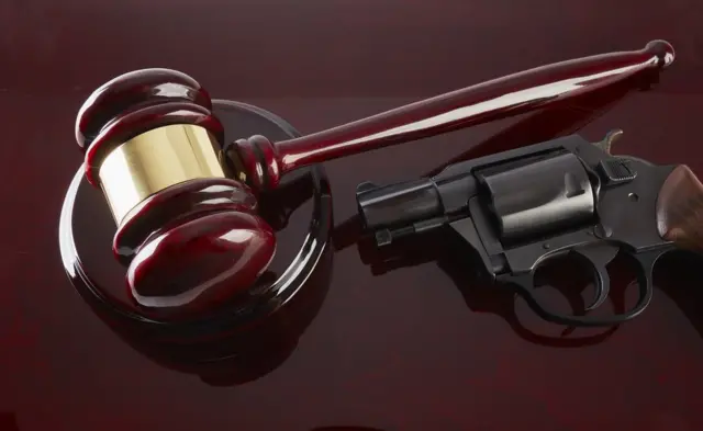 Martillo de juez y revólver