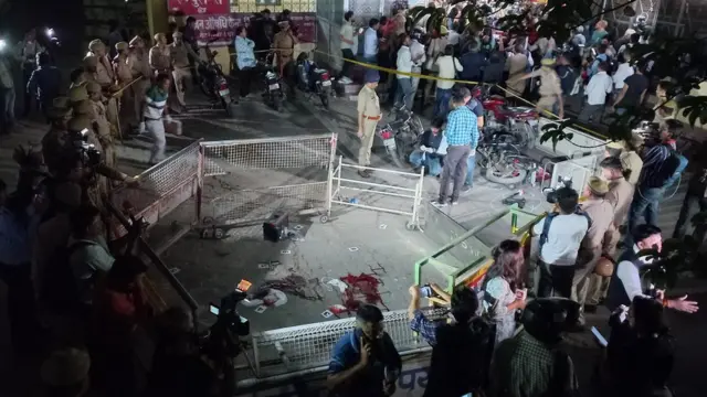 Varias personas se reúnen alrededor de la escena del crimen acordonada en la que Atiq Ahmed fue asesinado junto con su hermano, en las instalaciones del MLN Medical College en Prayagraj (Allahabad), India, a finales del 15 de abril de 2023 (publicado el 16 de abril de 2023).