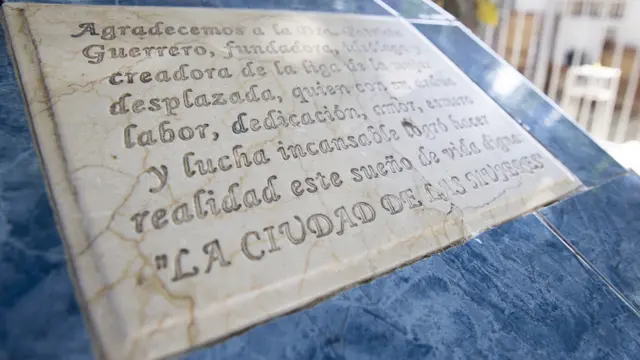 Sebuah plakat bertulisan "La Ciudad de Mujeres," atau "Kota Perempuan," terletak di tengah kota.