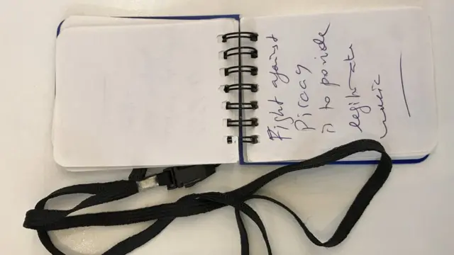 A small notebook with the words "Fight against piracy to provide legitimate music"