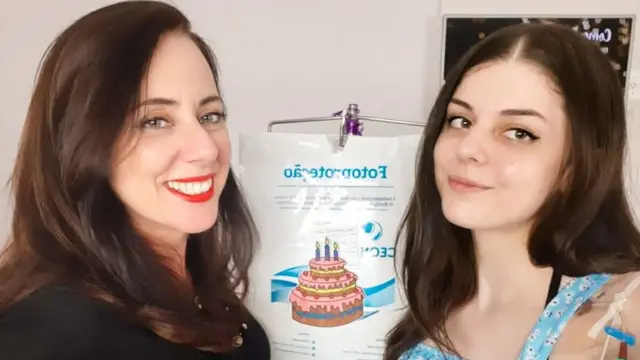 Fernanda e mãe sorriem para foto dentrocadastro loteria onlineambiente interno