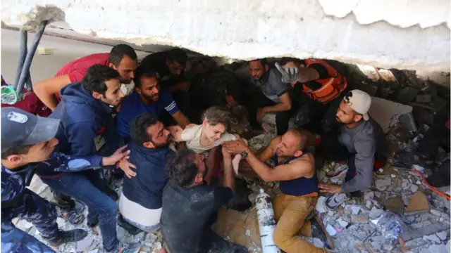 গত মে মাসে গাজায় ইসরায়েলের হামলায় ধসে পড়া ভবনের নিচ থেকে উদ্ধার করা হচ্ছে।
