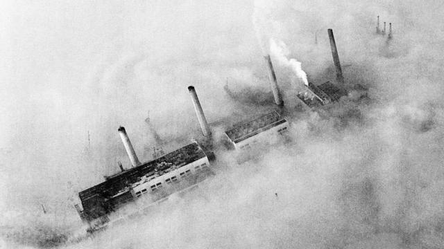 Les cheminées d'une usine de l'East End percent la couche de brouillard qui recouvre Londres. Vers 1952
