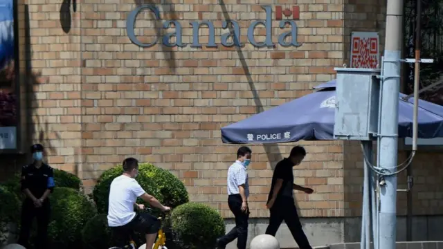 Gente pasando frente a la Embajada de Canadá en Pekín el 10 de agosto de 2021.