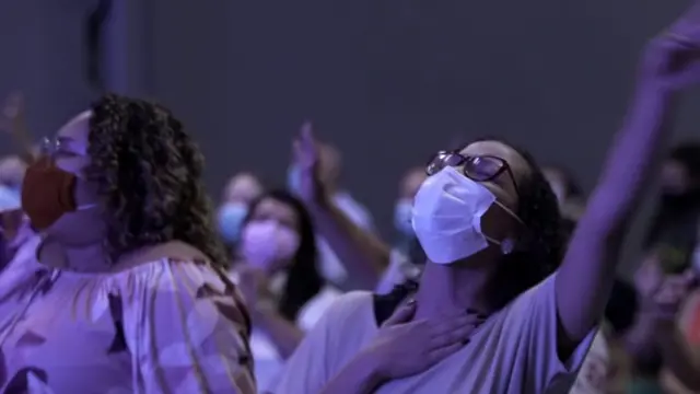 Femmes avec les mains en l'air lors d'un service religieux.