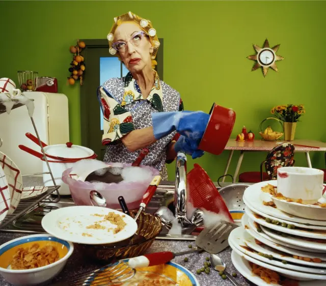 Mujer lavando platos sin prestar atención