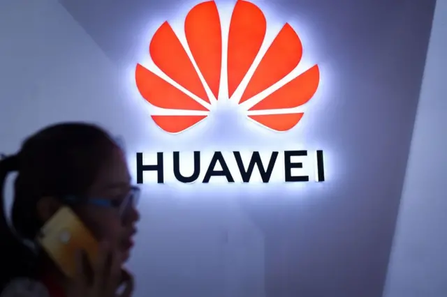 Pessoa fala ao telefonebaixar bet365 iphonefrente a logo da Huawei