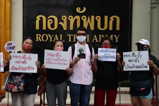 ผู้ประท้วงถือป้ายหน้ากองทัพบก