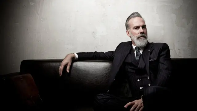 Millonario sentado en un sofá.