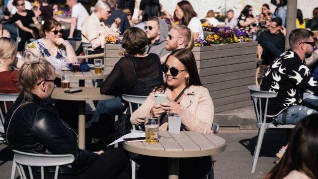 Pessoas em terraços na Finlândia em junho
