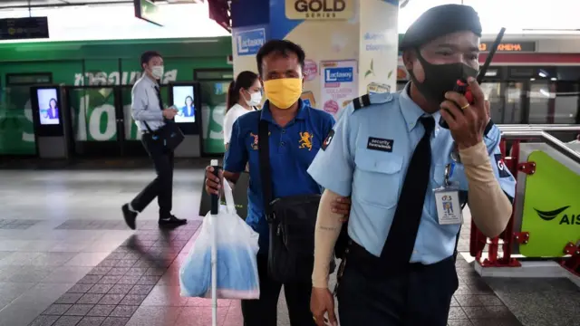 รปภ.ของรถไฟฟ้าเดินนำเพื่อให้คนตาบอดจับแขนเข้าขบวน