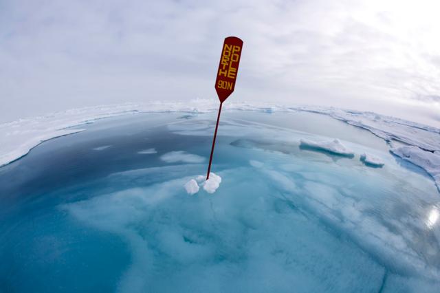 North Pole sign surrounded by water and ice