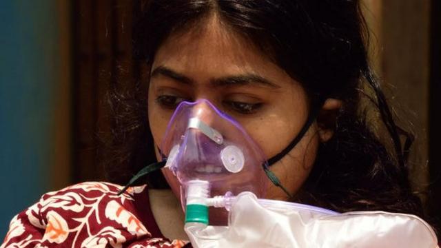 Pacientes de Covid-19 usam máscaras de oxigênio fora de um hospital antes da internação, pois a situação de pandemia piorou drasticamente no condado de Calcutá, Índia, em 24 de abril de 2021
