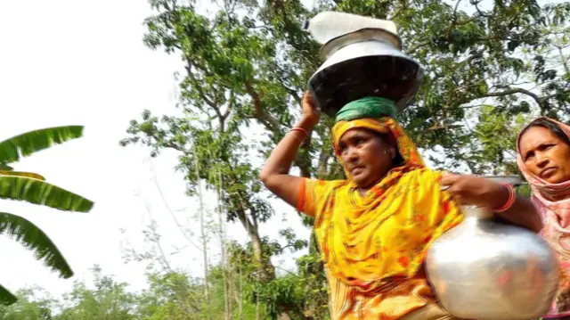 প্রায় এক কিলোমিটার দূর থেকে প্রতিদিন খাবার পানি সংগ্রহ করেন রাজশাহীর তানোরের বাসিন্দা জাস্টিনা হেমব্রম 