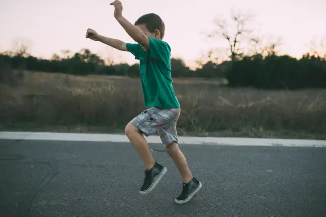 Umuhungu ariko ariruka mw'ibarabara 