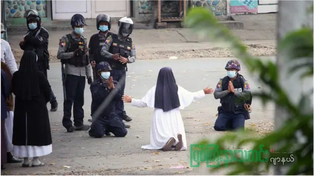 ২০২১ সালের মার্চে পুলিশের সামনে হাঁটু গেড়ে বসা একজন নান।