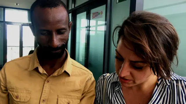 Un hombre y una mujer en una oficina miran algo juntos.