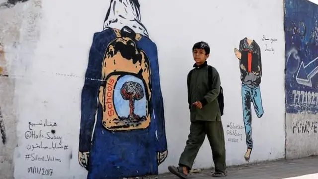 تحكي الجدارية قصة طفل بترت ساقه بسبب الألغام يقدم ساقه هدية للعالم الذي لا يكترث، وطالبة ترتدي الزي المدرسي وحقيبتها المدرسية مرسوم عليها صورة تفجير، كما قالت الرسامة اليمنية