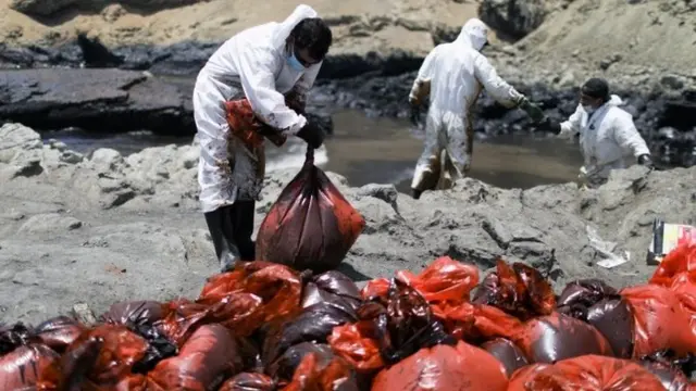 Empleados de Repsol limpian las playas en Perú.