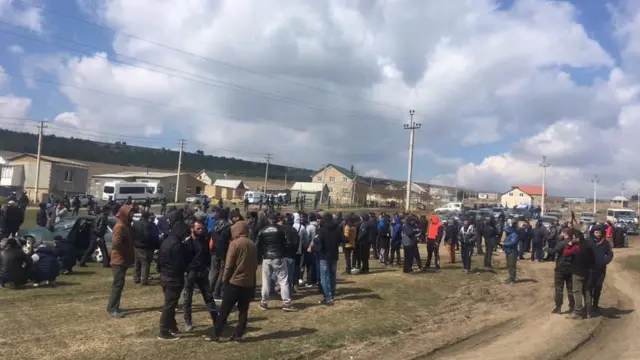 Люди біля будинків, де проводять обшук