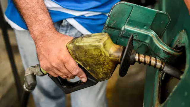 Hombre llenando tanque de gasolina.