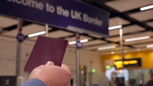Homem exibindo passaporte em controle de fronteira