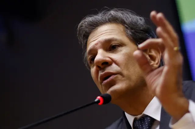 Haddad gesticulando com a mão e falando ao microfone