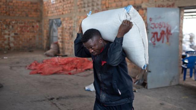 Trabajador carga bolsa con cobalto en Kolwezi, Congo.