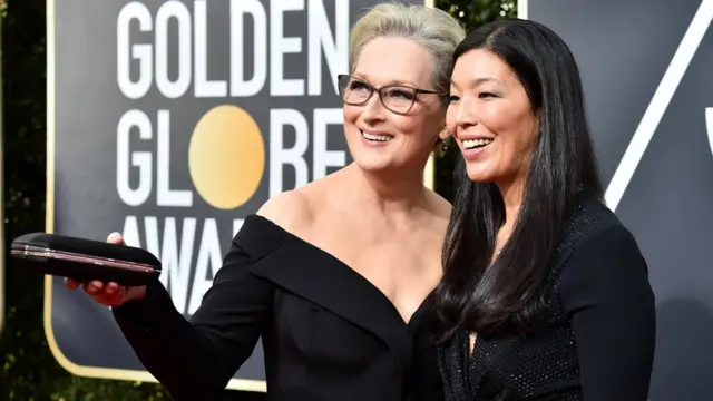 梅莉·史翠普（Meryl Streep）穿着一身黑色跟一名活动人士一起走了红地毯