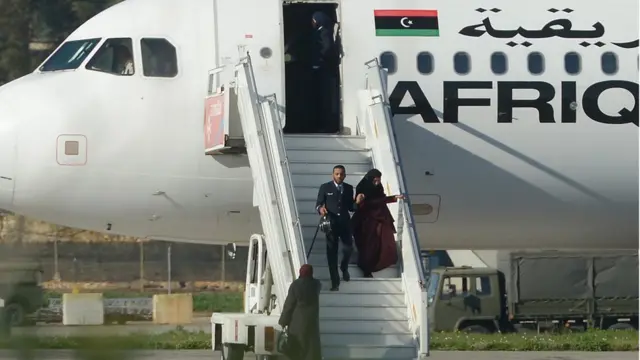 أحد أفراد طاقم الطائرة المختطفة وهو يساعد إحدى الراكبات لدى نزولها في مطار مالطا الدولي