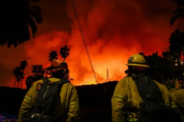 Bomberos viendo los incendios en la noche.