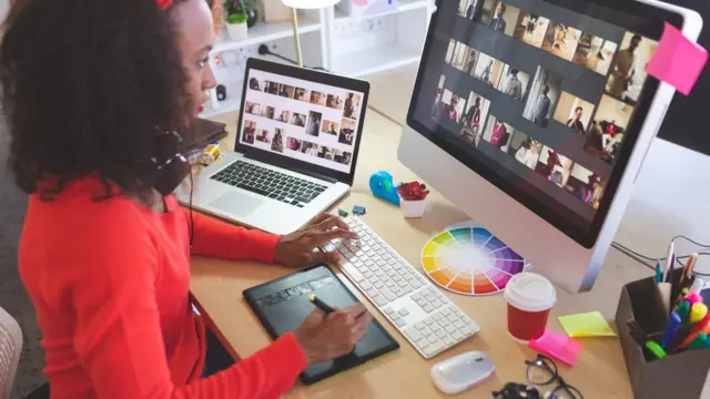 Graphiste travaillant sur deux écrans, elle essaie de se concentrer.