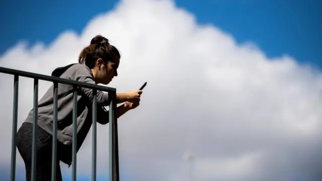 امرأة تتصفح هاتفها المحمول