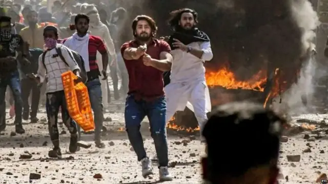 दिल्ली में सोमवार को हुई हिंसा में लाल शर्ट पहना एक व्यक्ति पिस्तौल के साथ नज़र आया