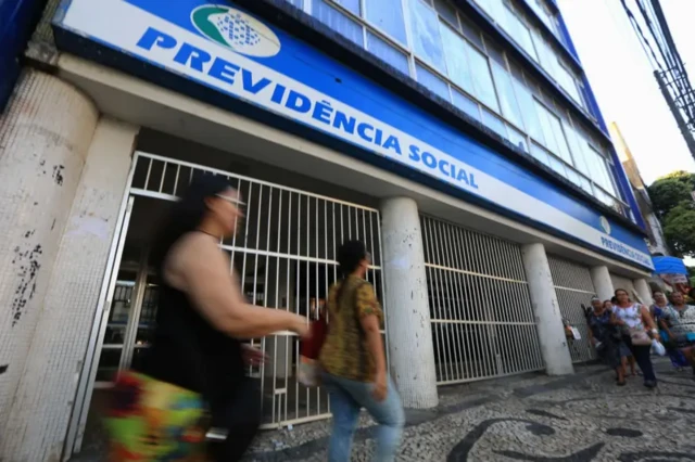 Pessoas passam em frente à agência do INSS