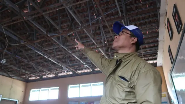 Kepala Sekolah SDN Cibentang 02, Oboh Khaerul Misbah sedang mengamati atap bangunan ruang kelas.