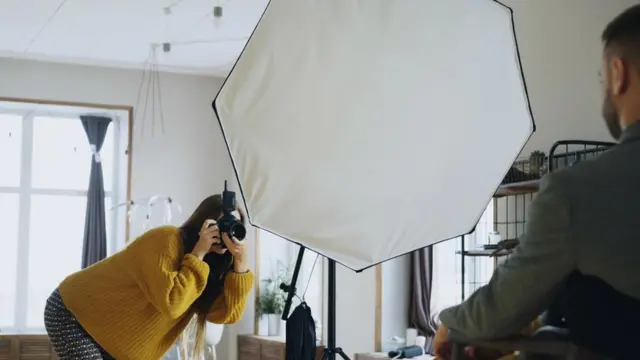فتاة تلتقط صورة احترافية لشاب في غرفة التصوير