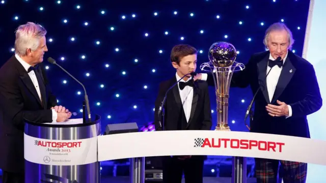 14-річний Ландо Норріс отримує нагороду від триразового чемпіона світу сера Джекі Стюарта на церемонії Autosport Awards 2013 року.