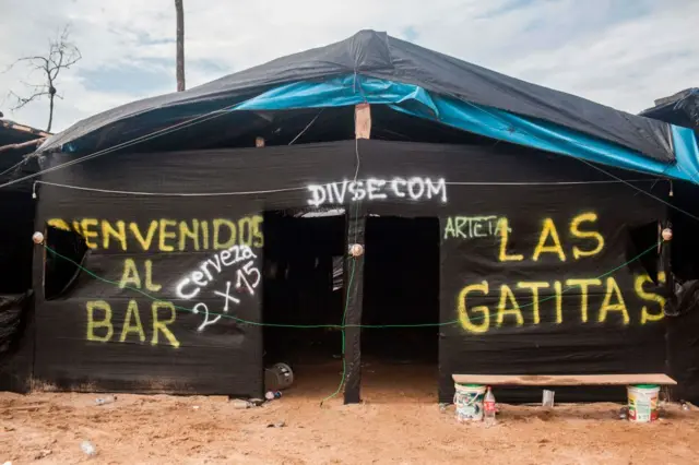 Una carpa con el mensaje "Bienvenidos al bar Las Gatitas", en la región de La Pampa, en la selva de Perú. 