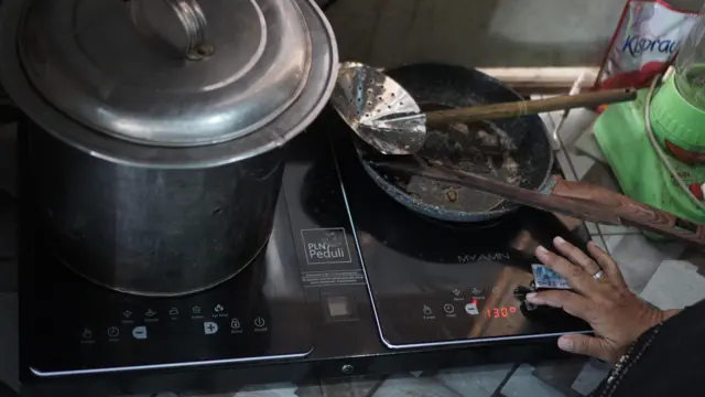 Warga memasak menggunakan kompor listrik induksi di Kampung Mojo, Semanggi, Solo, Jawa Tengah, Selasa (27/09)