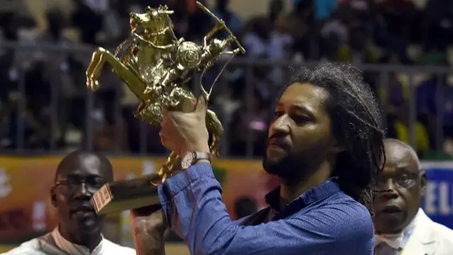 Le réalisateur franco-sénégalais Alain Gomis soulève l'Étalon de Yennenga, le Grand Prix du Fespaco qu'il a remporté en 2013 et 2017.